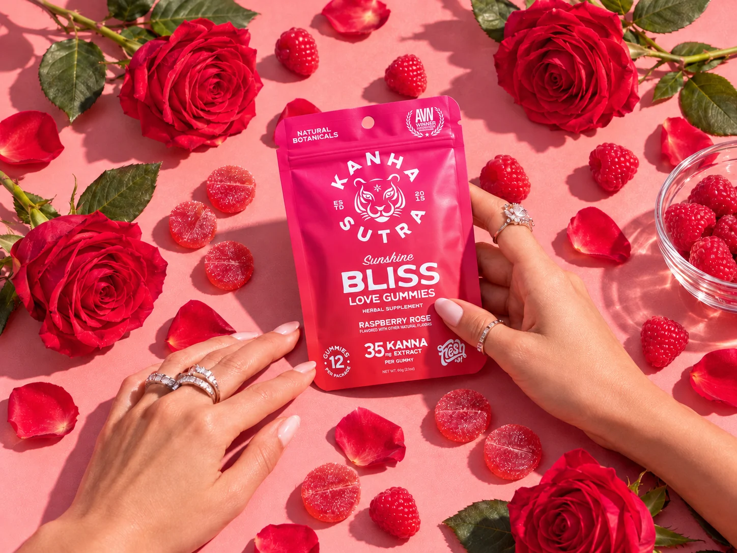 Sunshine Bliss gummies, rose petals, and hands holding the pack